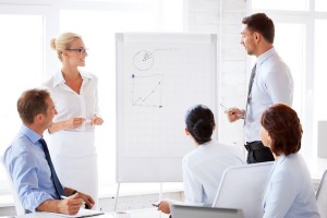 smiling business team working with flip chart in office